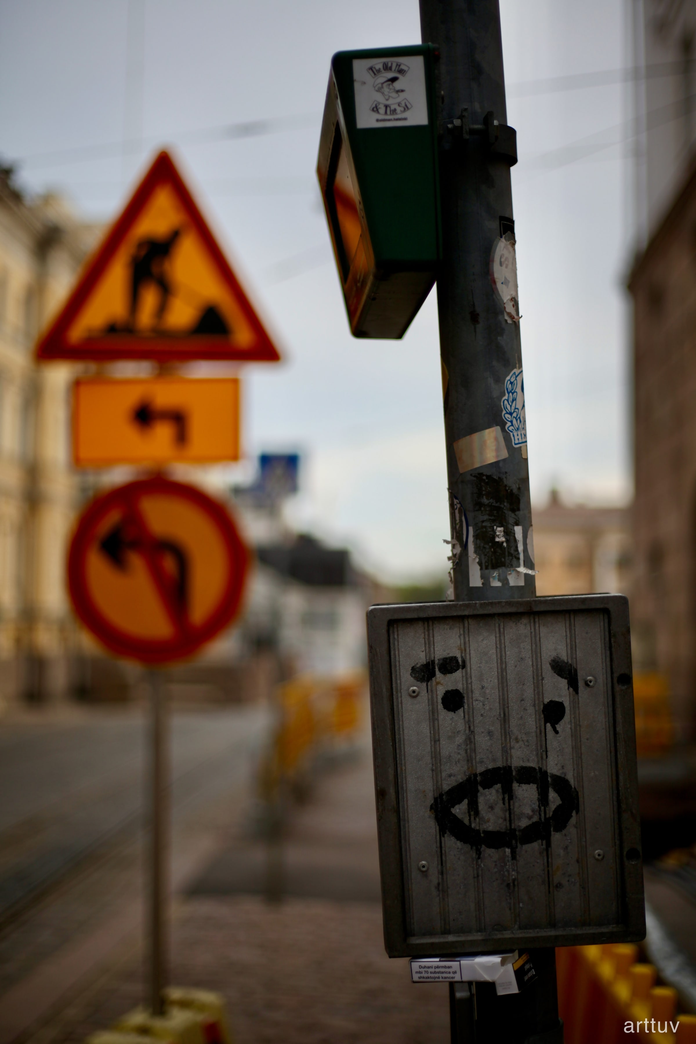 A shallow-focus street scene with a green Old Town sign mounted on a pole and blurred road signs in front.